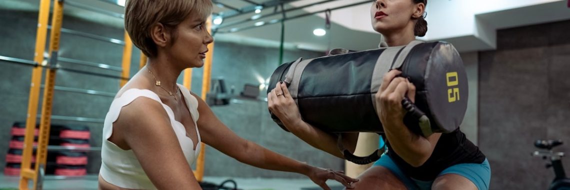 A man and a woman doing squats in a gym